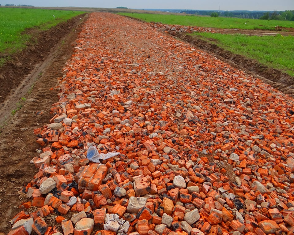 Бой кирпича. Отсыпка дороги боем кирпича. Дорога из битого кирпича. Бой кирпича для дороги.